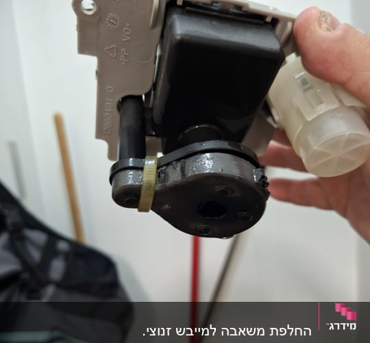 טכנאי מחזיק רכיב חשמלי פנימי במהלך תיקון מוצר חשמל